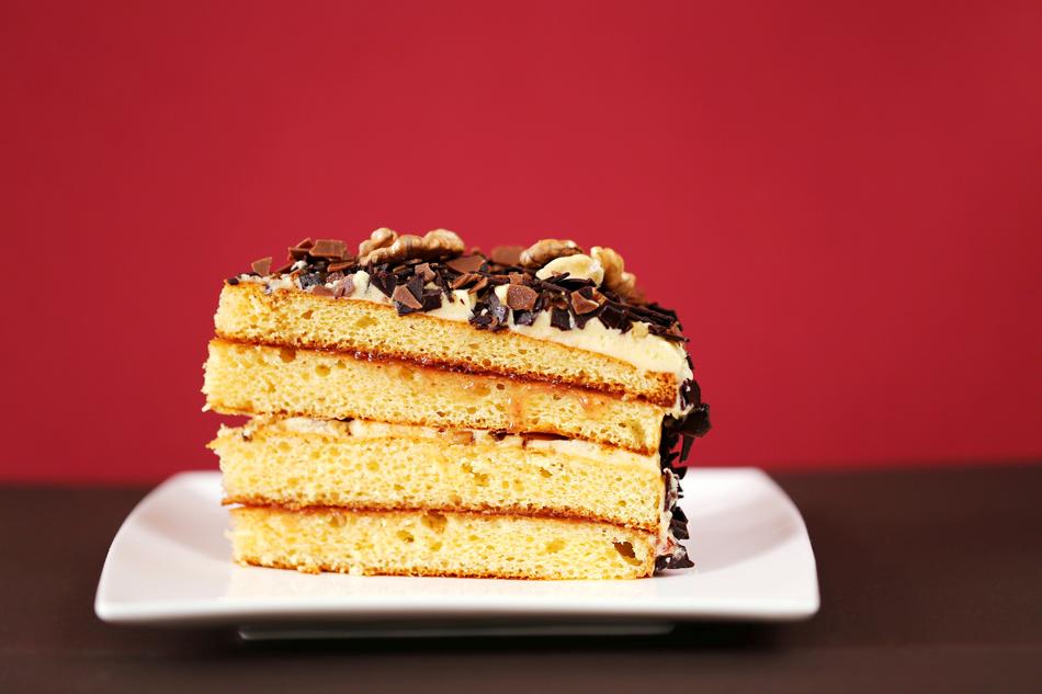 a piece of cake on a plate on a burgundy background