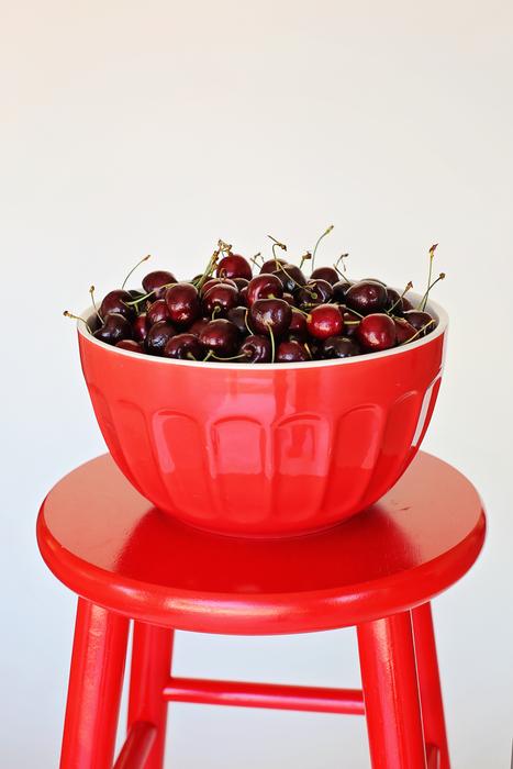 Beautiful, red bowl of cherries, on the red chair