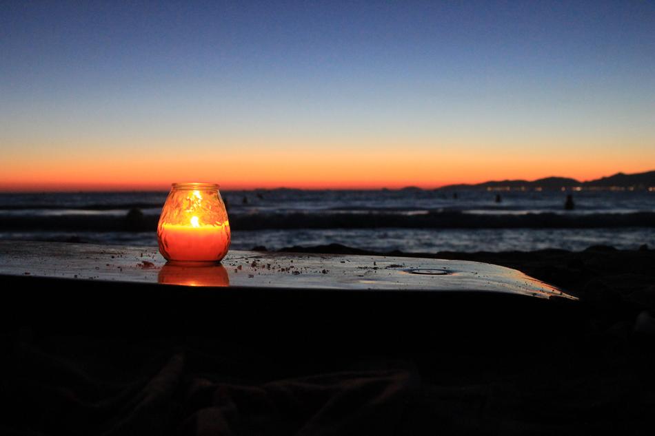 photo of a burning candle on the seashore in Corsica