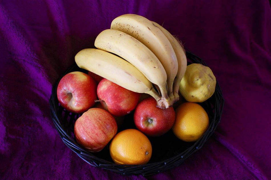 Banana and apples in bowl on purple tissue