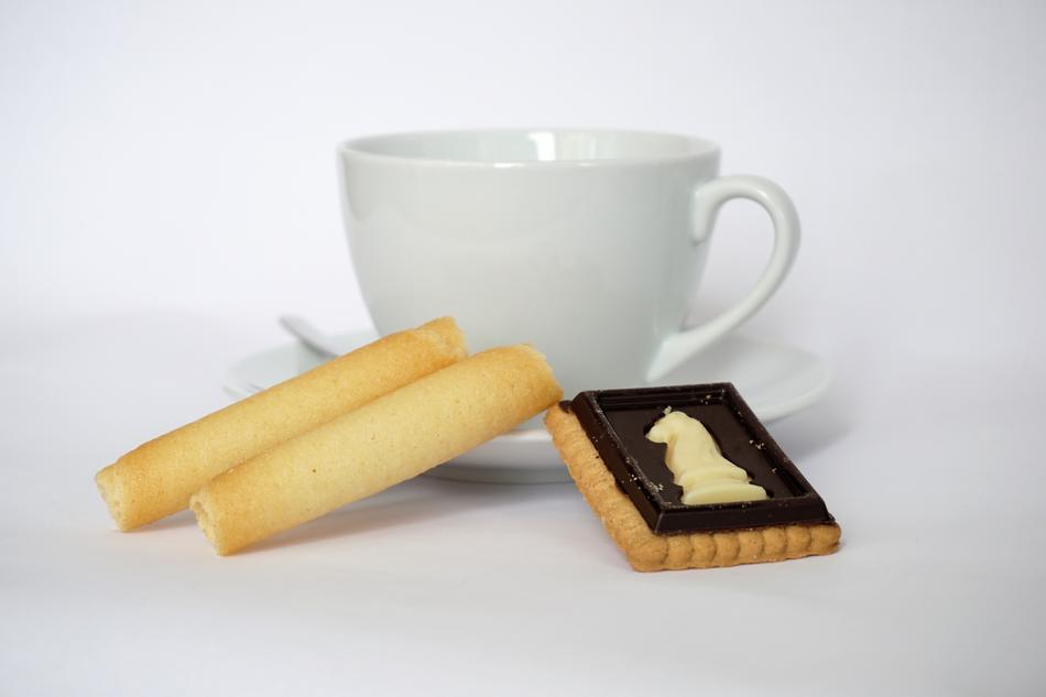 white cup and biscuit