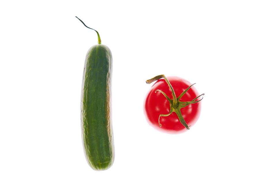 Up view of the green cucumber and red tomato, on the white surface
