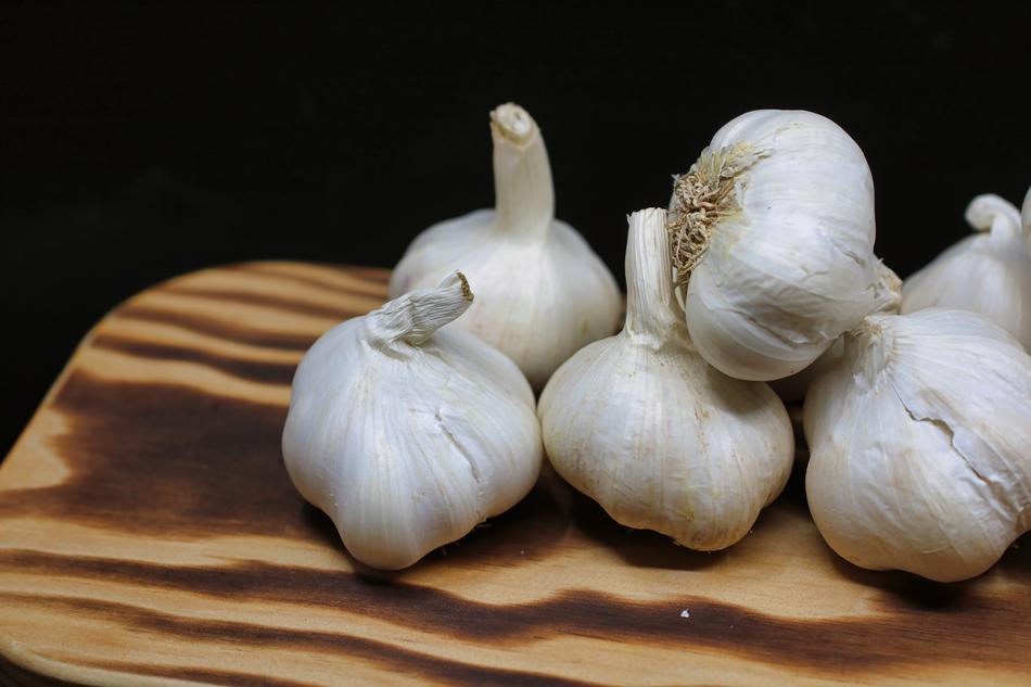 white garlic on a wooden cutting board