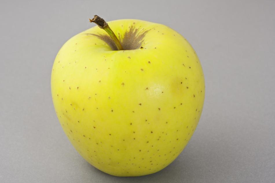 yellow Apple with tiny brown spots close up