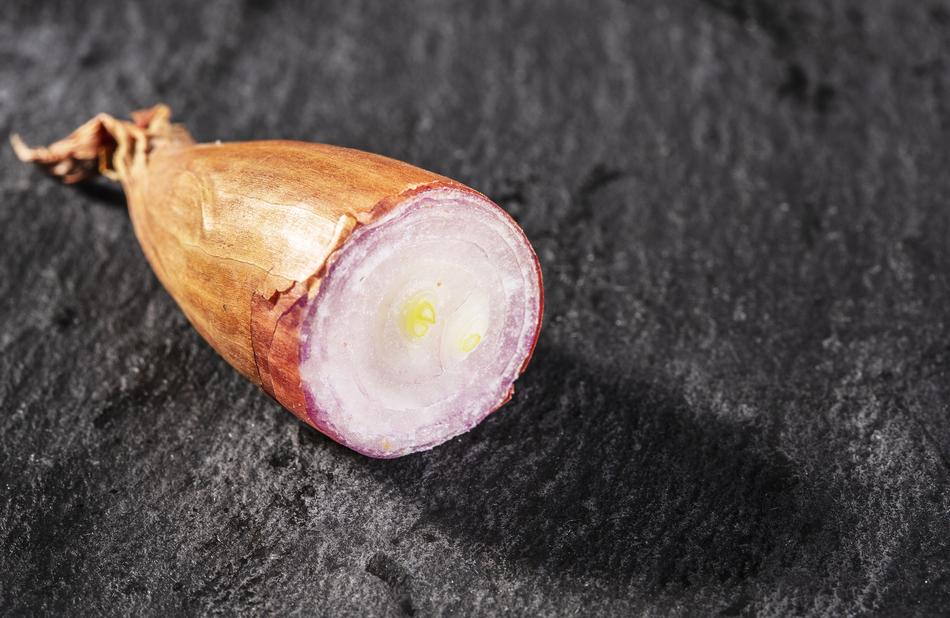 half shallots on a black table