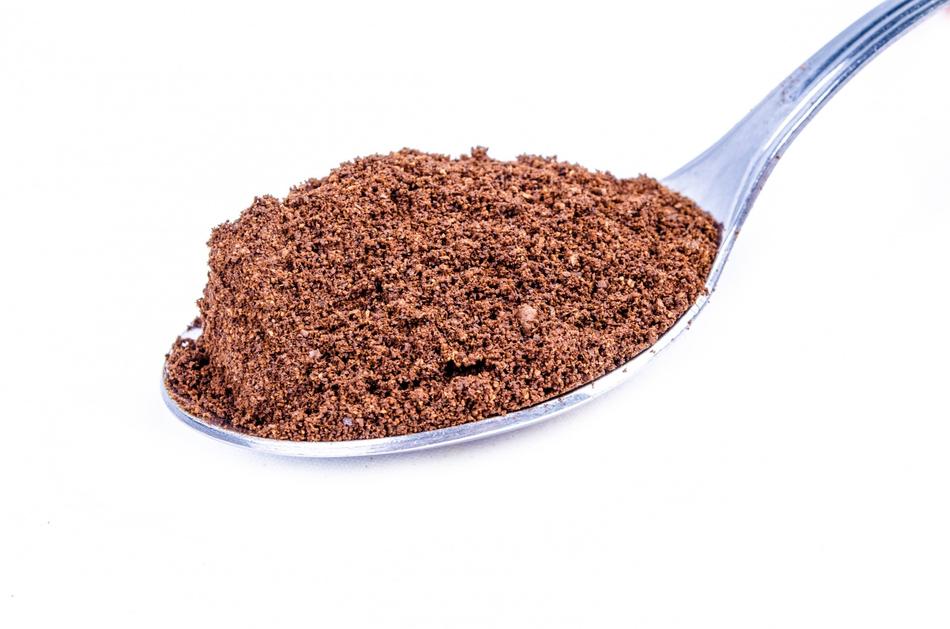 Close-up of the brown sugar in metal spoon, at white background