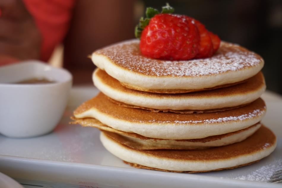 Stack of the beautiful pancakes with red strawberry and in sugar powder