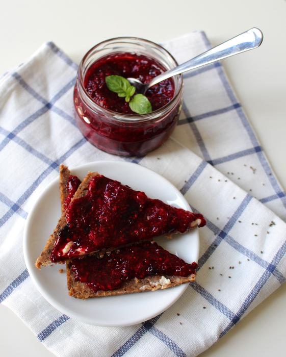 Beautiful Jam sandwiches with chia seeds near the jar with jam and spoon, on the checkered cloth