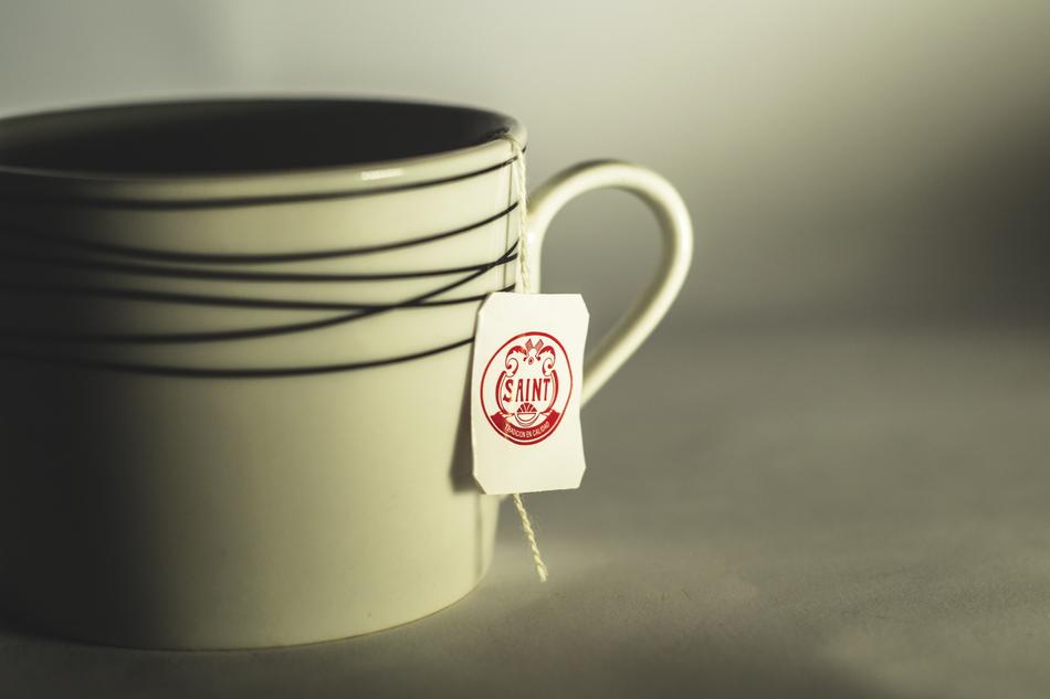 Shiny cup with black lines, with teabag inside, in light