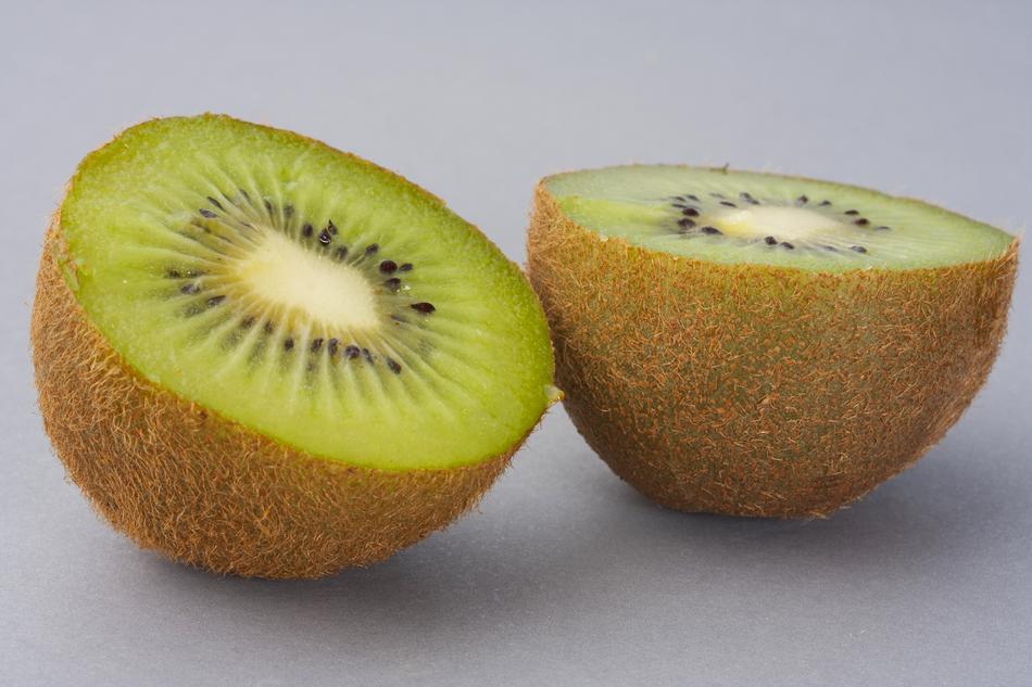 Halves of the beautiful, green kiwi, with brown shell