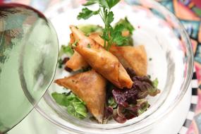 Closeup of the food made of the dough, with vegetables, in the glass bowl