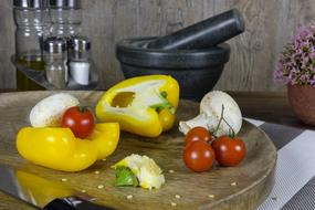 yellow peppers, mushrooms and tomatoes on a cutting board