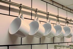 white porcelain mugs hanging in the kitchen