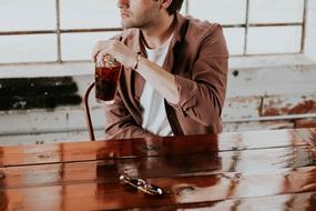 man drinking soda in cafe