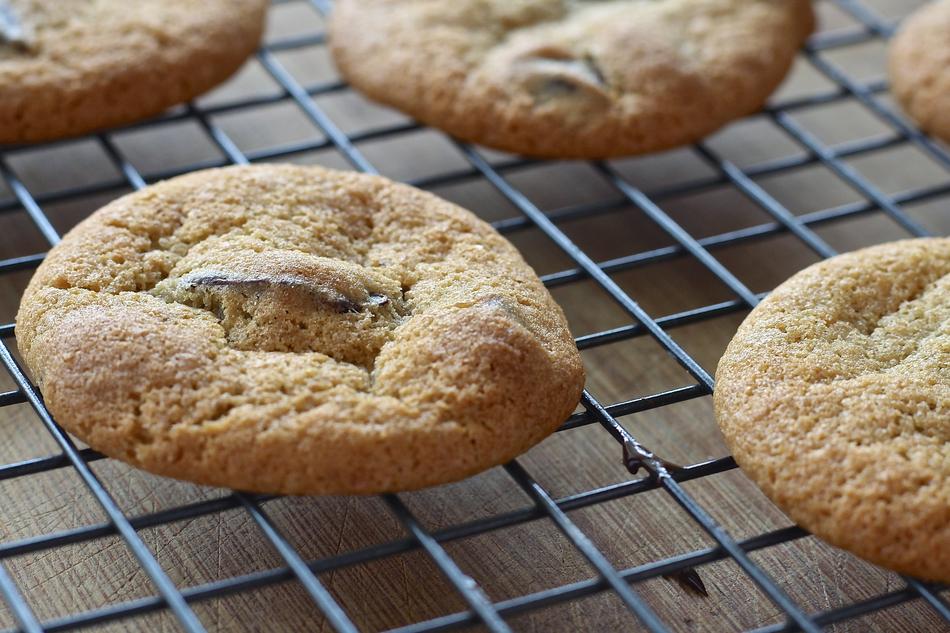 Close-up of the beautiful cookies on the metal grill, above the wooden surface