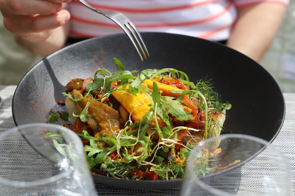 person holds fork over Vegetable and meat Meal