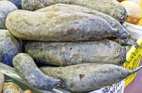 Yam, sweet Potato, raw vegetables on market stall