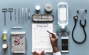 medical tools and male hands filling Daily Report form on table