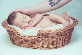 newborn in a wicker basket at a photo shoot