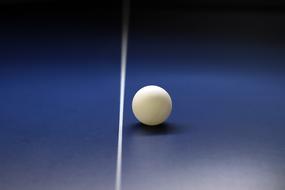 white tennis ball on a blue table