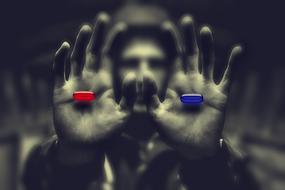 photo of a red and blue pill in the hands of a man