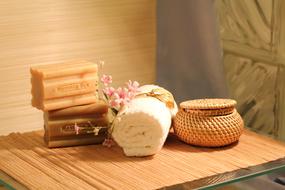 organic soap, towel and flowers on the table in the bathroom