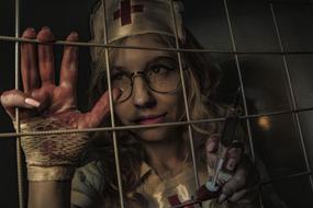 spooky nurse with Syringe behind grates