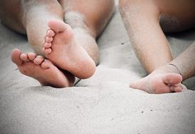 bare feet of children on the sand at the beach