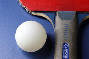 Macro photo of a tennis racket handle and ball on a table