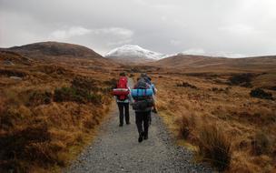 group of people with backpack on Hiking trail to scenic mountains, ireland