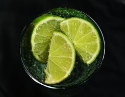 water with lime in a glass on black