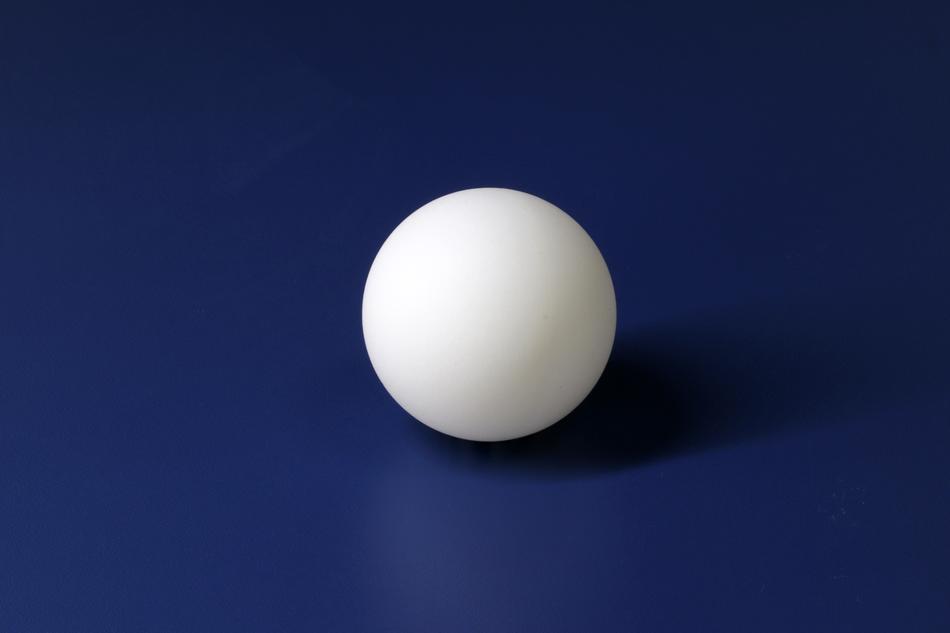 white Ping-Pong ball on the blue background
