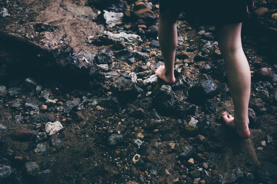 barefoot on dark rocks