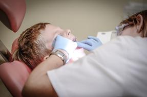 Dentist works with child boy