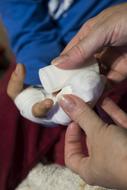 woman putting bandage on Child Boyâs Injury