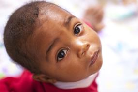 face of african baby boy looking up