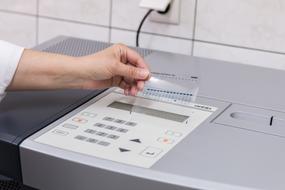 Analysis in Diagnostic Laboratory, female hand with film at equipment