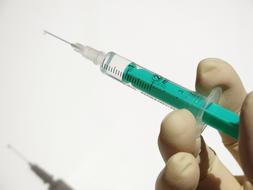 Medical Syringe in Fingers
