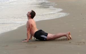 man doing stretching on the beach