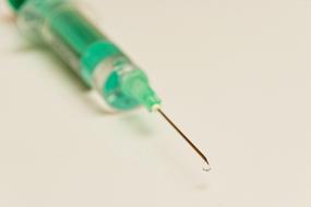 green syringe and sharp needle