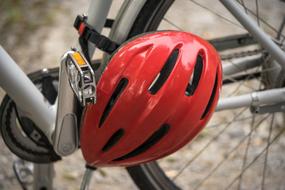 red helmet is hanging on a bicycle