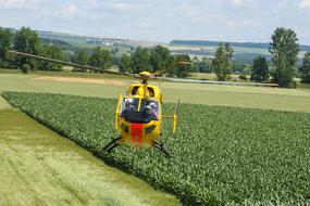 Rescue Helicopter landing near field in countryside