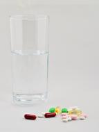glass of water and multi-colored pills
