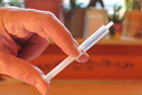 syringe in hand on blurred background