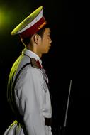 Profile portrait of the soldier in hat, in light, at black background