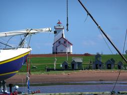 Beautiful landscape with the white and red lighthouse and ship on the Prince Edward Island in Canada