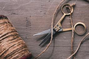 Beautiful, brown hemp cord and scissors on the wooden surface