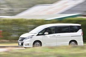 white hybrid car in motion in blurred background