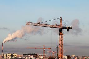 Construction Cranes at evening sky above city