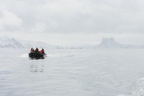 people sail by boat past glaciers in Antarctica